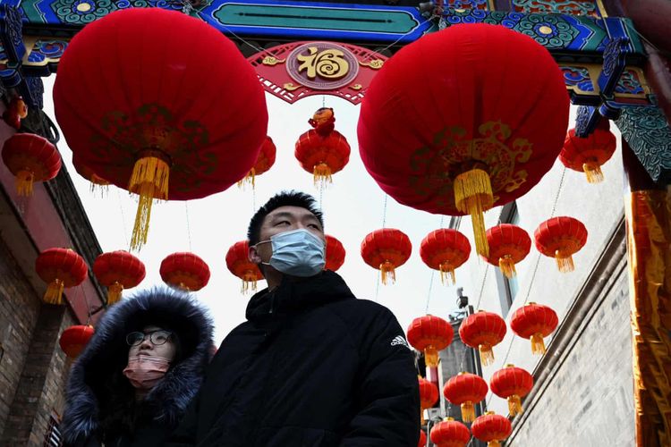 Mọi người đi dạo dưới những chiếc đèn lồng truyền thống một ngày trước khi bắt đầu năm mới ở Bắc Kinh.

