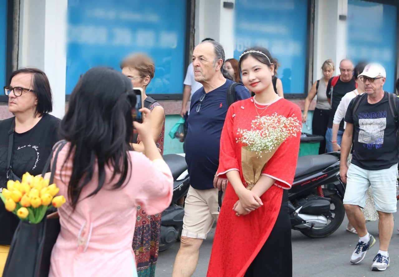 Bạn trẻ TPHCM diện áo dài rực rỡ chụp ảnh trước chợ Bến Thành - 9