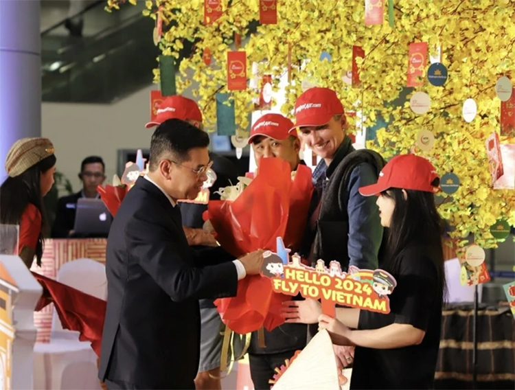 Phó Chủ tịch UBND TPHCM tặng hoa vị khách đầu tiên "xông đất" TPHCM - 1