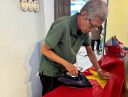 Trưởng khu phố tỉ mỉ ủi từng lá cờ trước ngày bầu cử