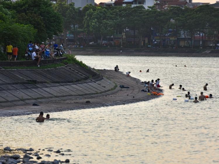 Hà Nội nắng nóng 37 độ C, người lớn, trẻ em biến hồ Linh Đàm thành bãi tắm để giải nhiệt