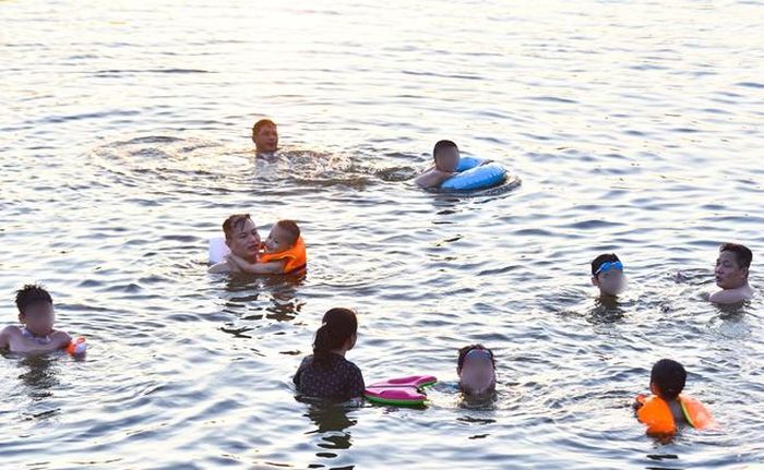 Hà Nội nắng nóng 37 độ C, người lớn, trẻ em biến hồ Linh Đàm thành bãi tắm để giải nhiệt - 11