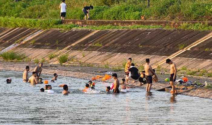 Hà Nội nắng nóng 37 độ C, người lớn, trẻ em biến hồ Linh Đàm thành bãi tắm để giải nhiệt - 13