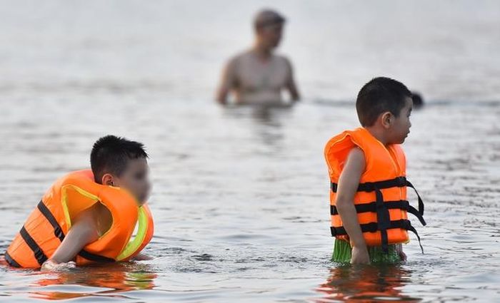 Hà Nội nắng nóng 37 độ C, người lớn, trẻ em biến hồ Linh Đàm thành bãi tắm để giải nhiệt - 4