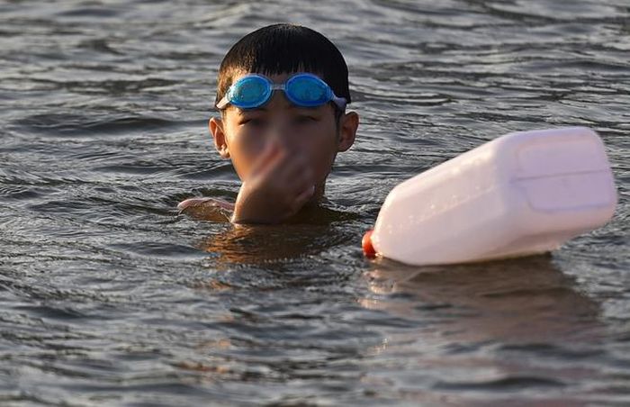 Hà Nội nắng nóng 37 độ C, người lớn, trẻ em biến hồ Linh Đàm thành bãi tắm để giải nhiệt - 9