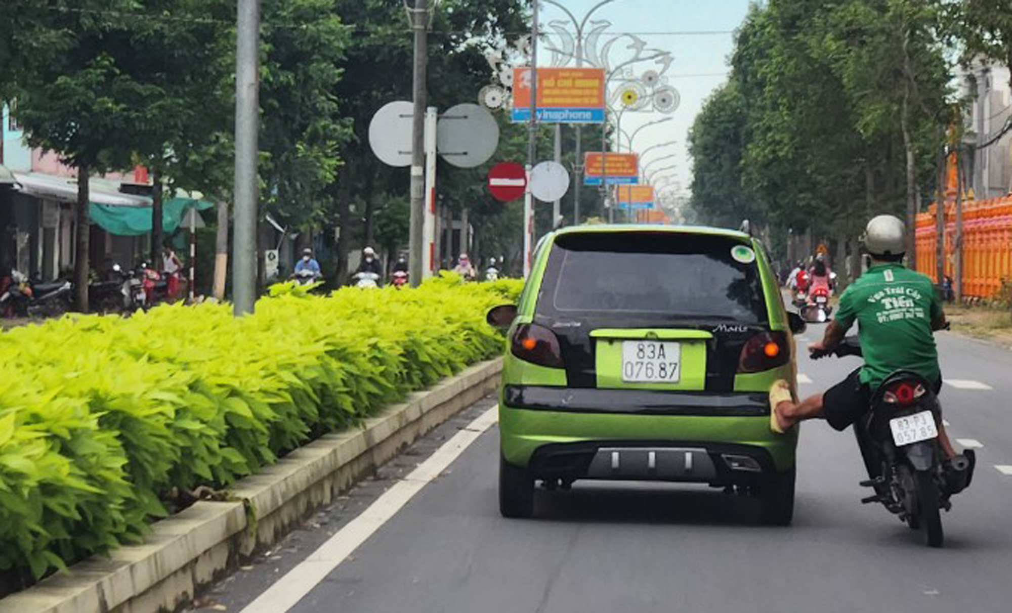 Phạt hành chính người đàn ông chạy xe máy đẩy xe hơi chạy bon bon - 1